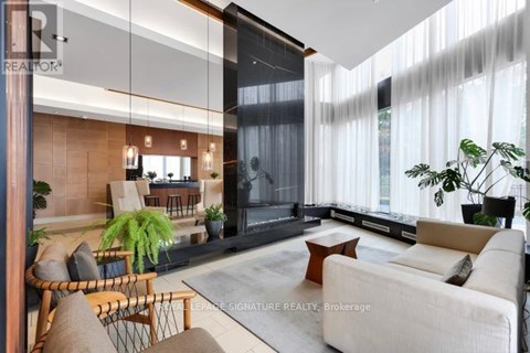 A living room with a white couch and a wooden chair.