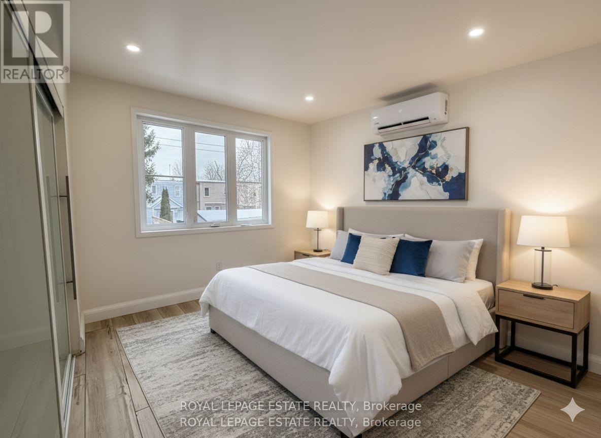 A bedroom with a large bed, a window, and a painting on the wall.