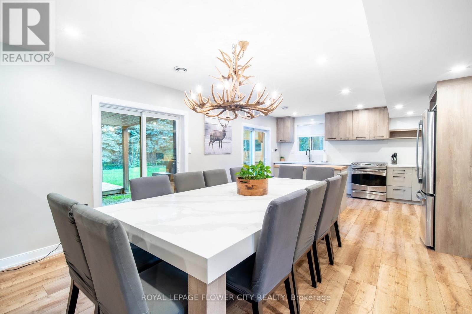A dining room with a white table and grey chairs.