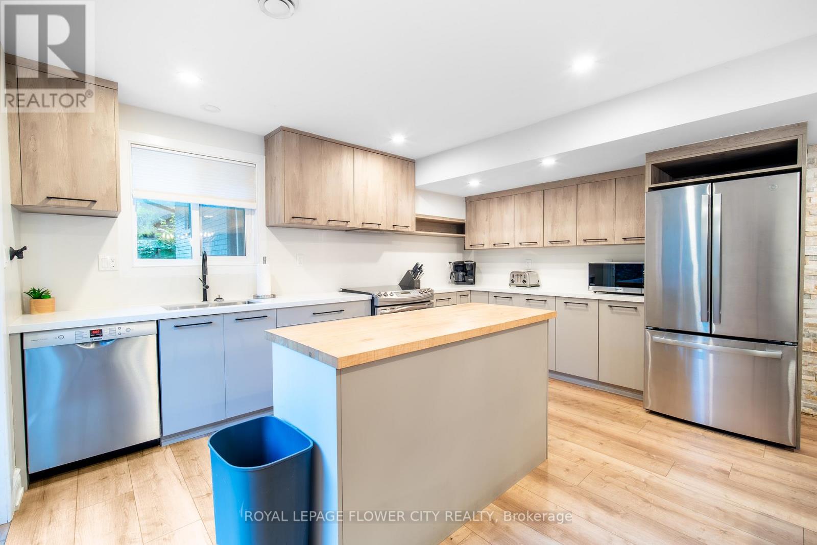 A modern kitchen with wooden cabinets and stainless steel appliances.