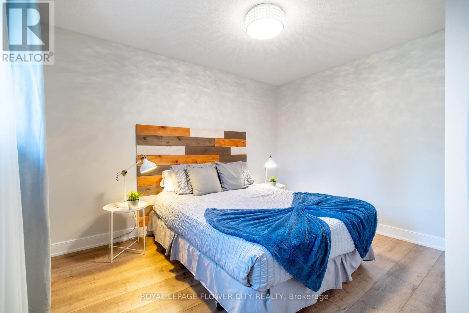 A bedroom with a bed covered in a blue blanket.
