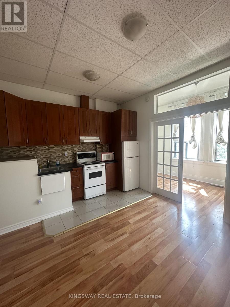 A kitchen with wooden floors and white appliances.