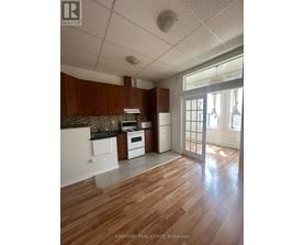 A kitchen with wooden floors and white appliances.