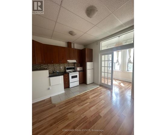A kitchen with wooden floors and white appliances.