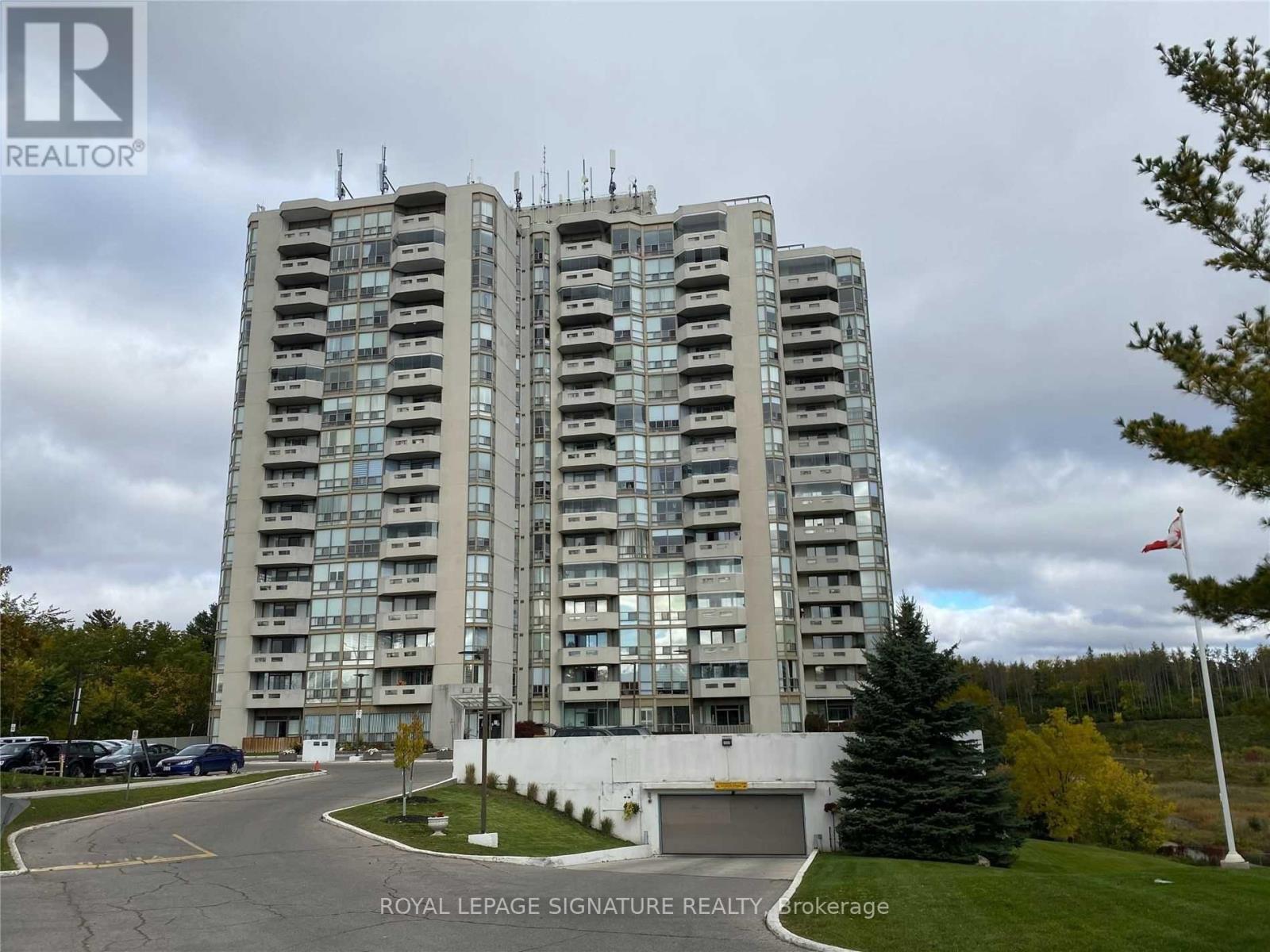 A tall building with a sign that says "Royal LePage Signature Realty Brokerage" in front of it.