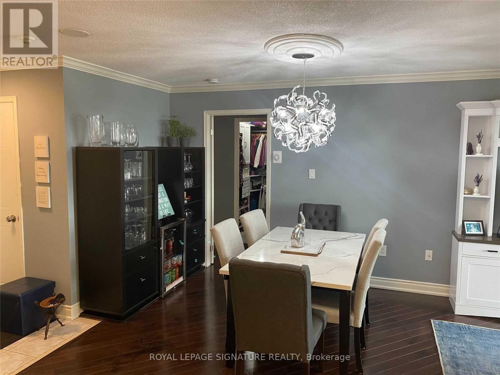 A dining room with a table set for two and a chandelier hanging from the ceiling.