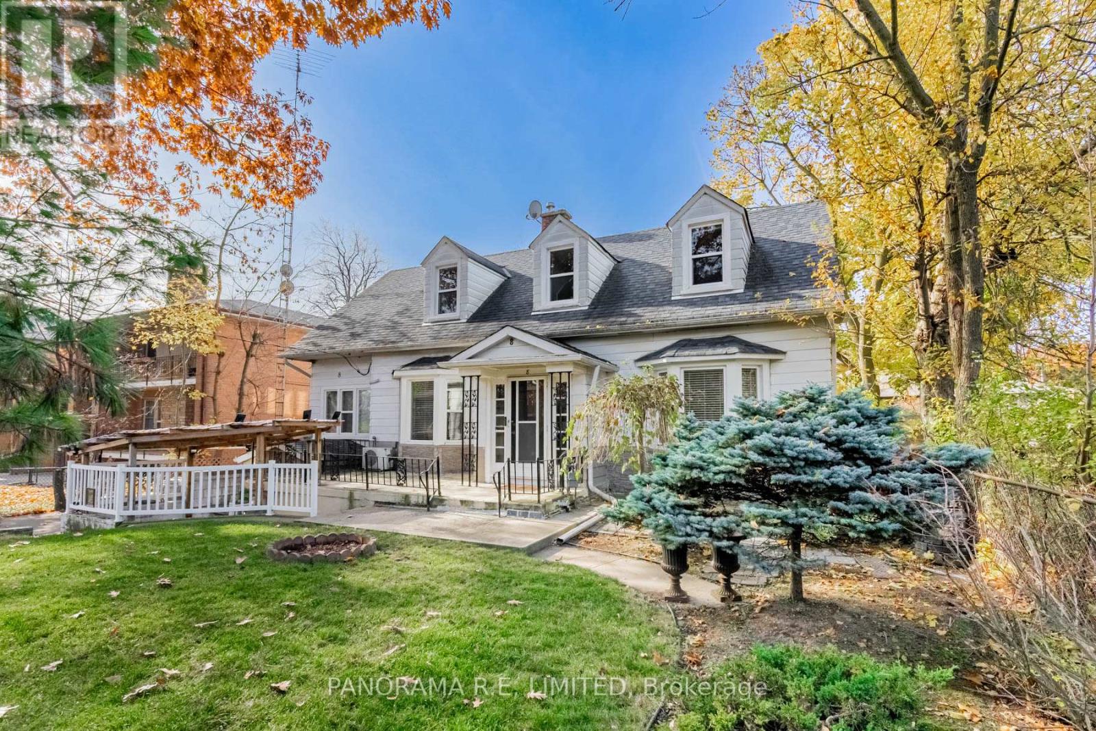 A house with a white picket fence and a tree with blue leaves.