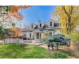 A house with a white picket fence and a tree with blue leaves.