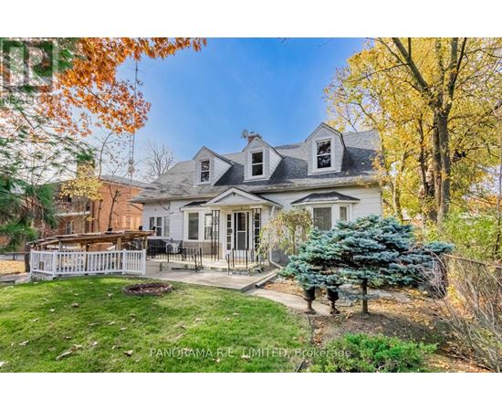 A house with a white picket fence and a tree with blue leaves.