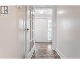 A hallway with a white door and a white wall.