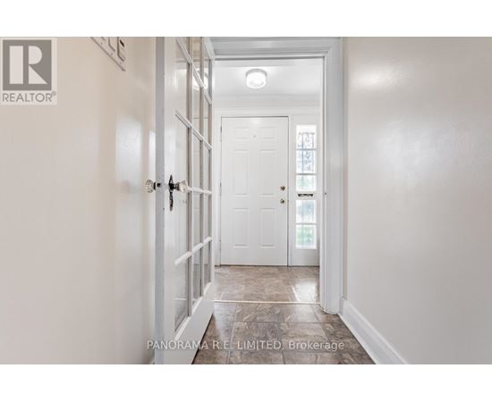 A hallway with a white door and a white wall.