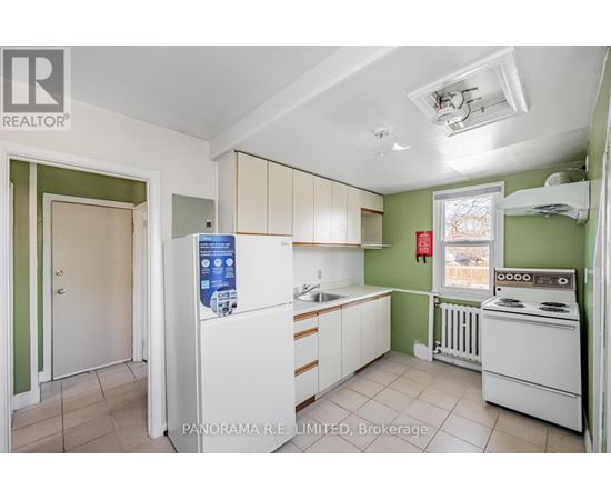 A kitchen with white appliances and green walls.