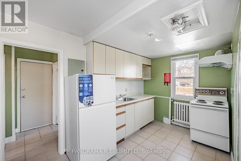 A kitchen with white appliances and green walls.