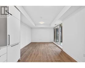 A spacious room with wooden flooring and white walls.