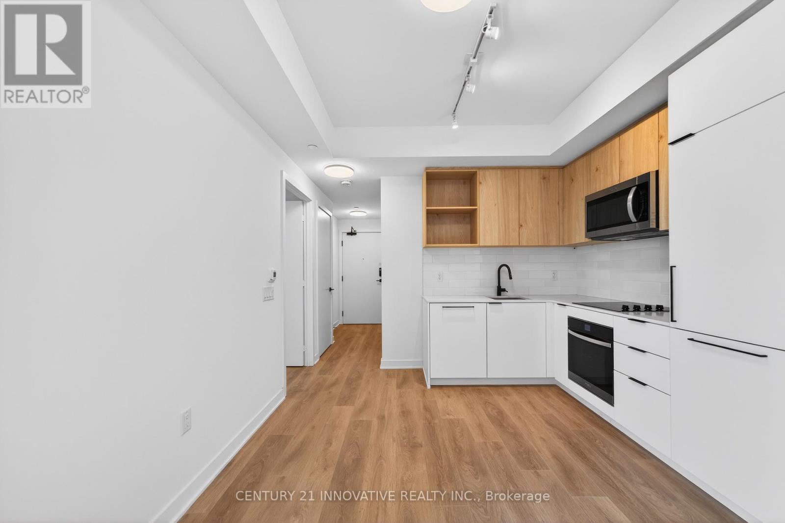 A kitchen with white cabinets and a wooden counter top.