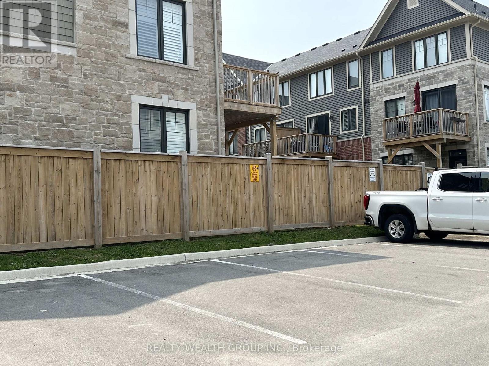 A white truck is parked in a parking lot in front of a building.