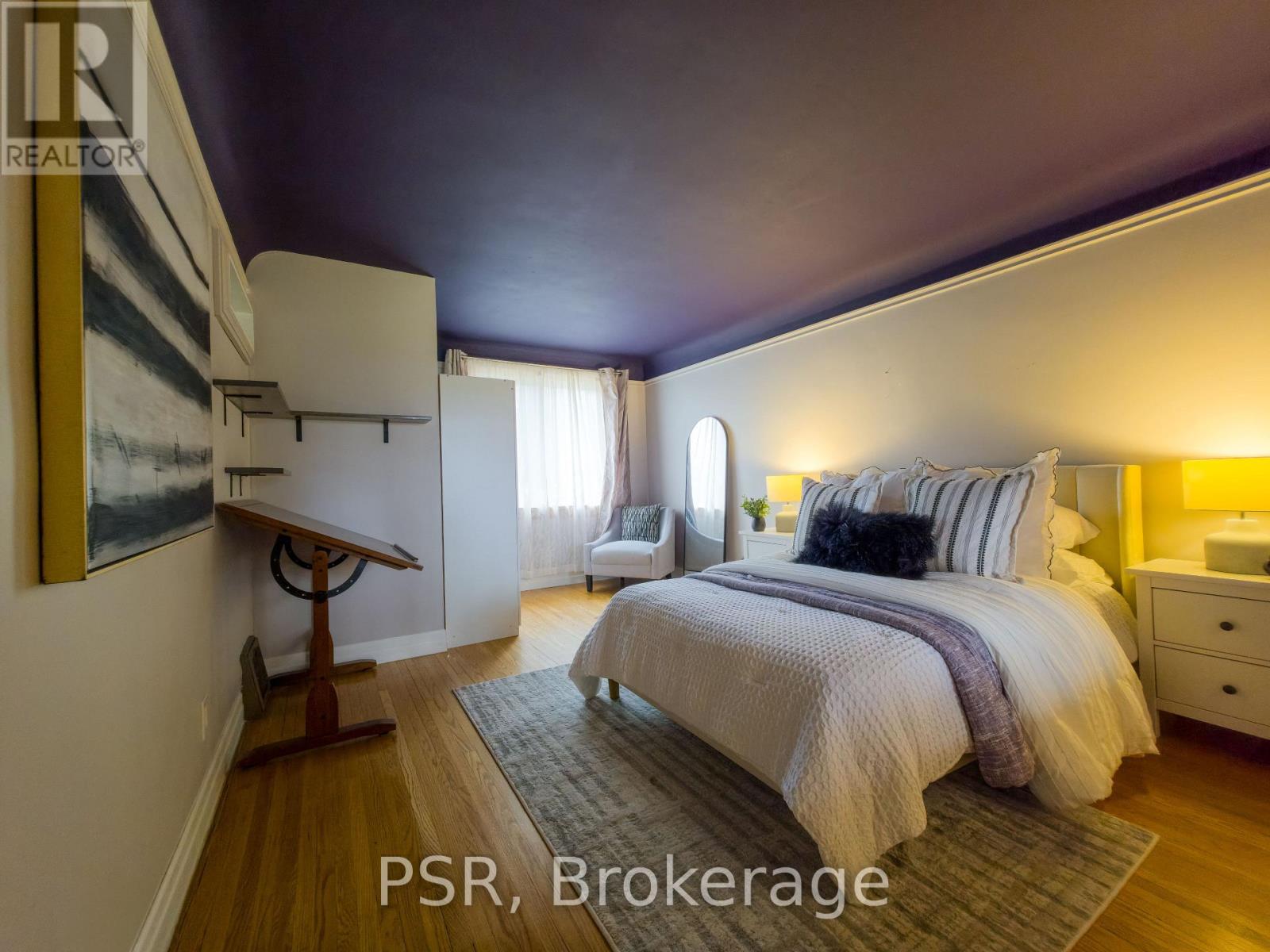 A bedroom with a bed, nightstand, and lamp.