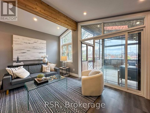 A living room with a grey couch and a glass table.