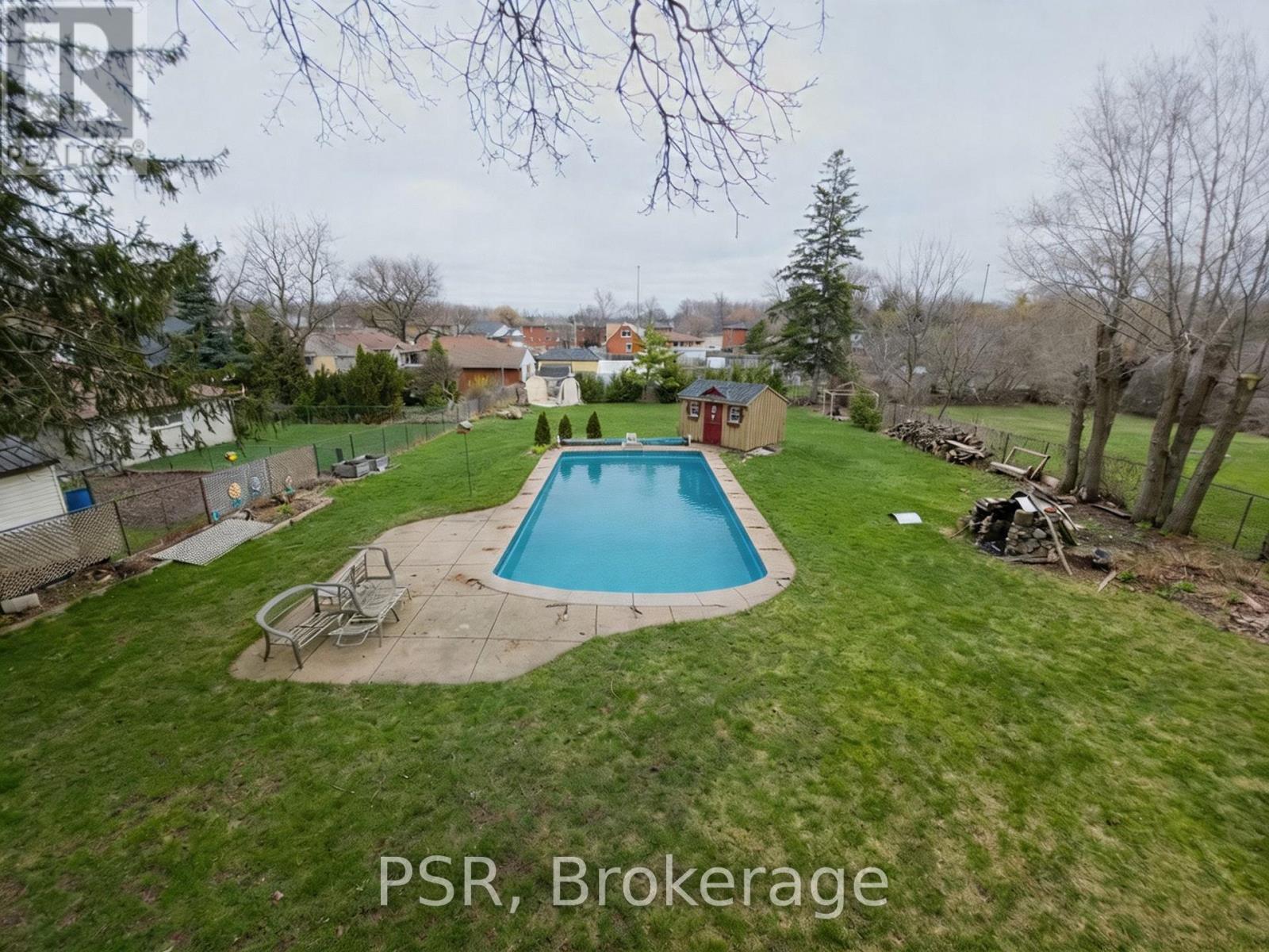A backyard with a pool and a deck.
