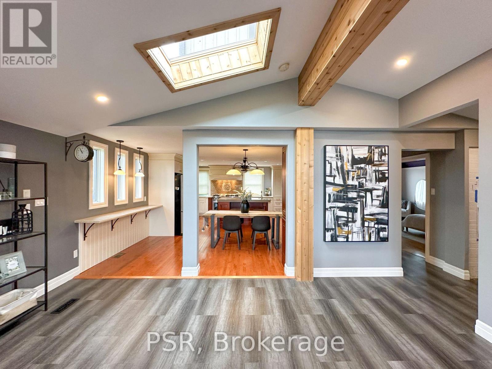 A spacious room with wooden floors and a skylight.
