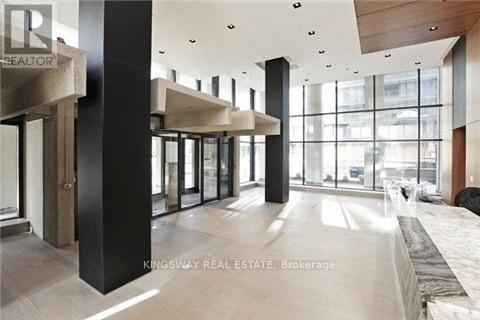 A modern interior space with a glass wall and a black column.