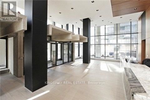 A modern interior space with a glass wall and a black column.