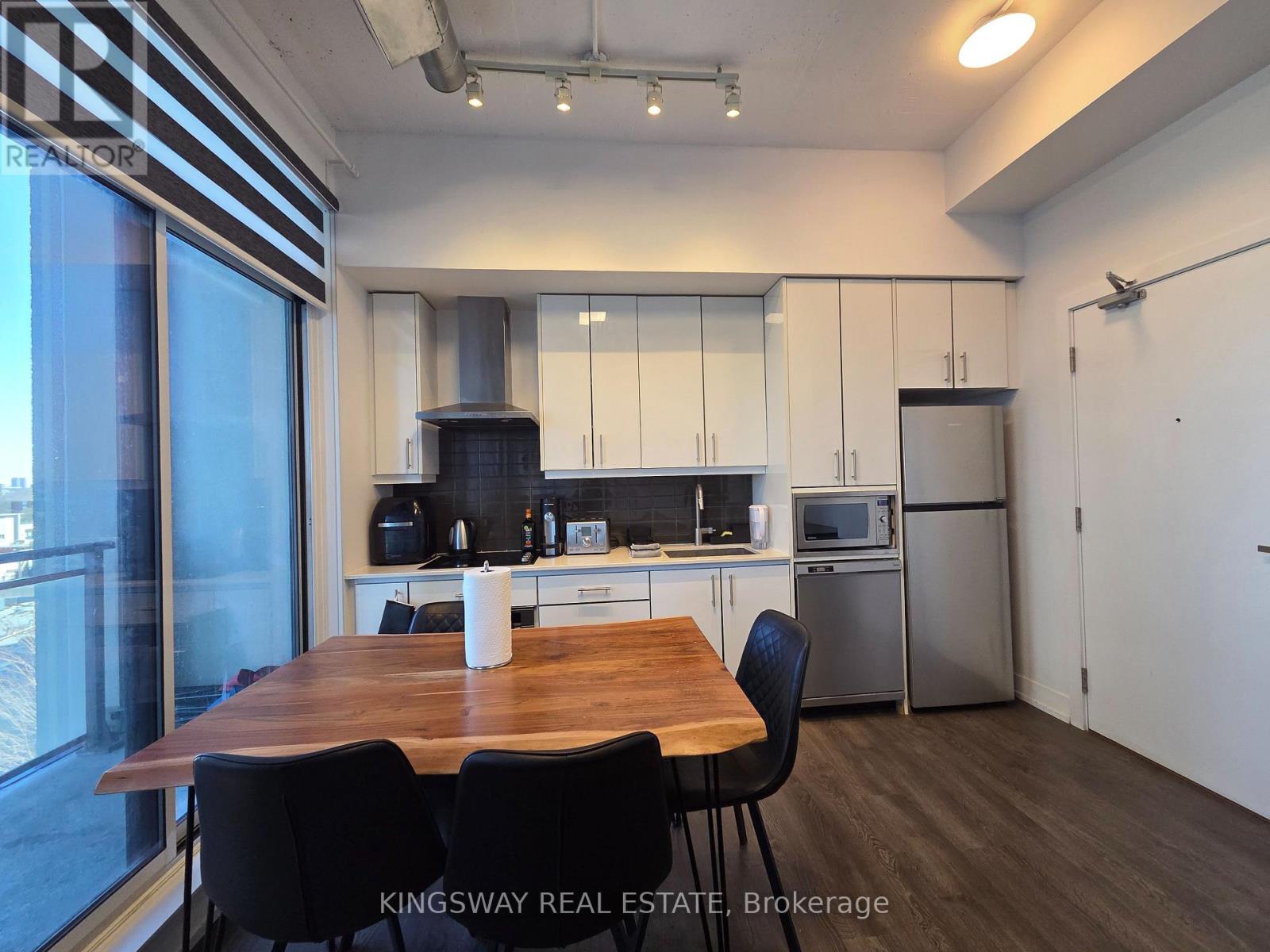 A kitchen with a table and chairs in front of a window.