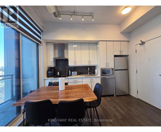 A kitchen with a table and chairs in front of a window.