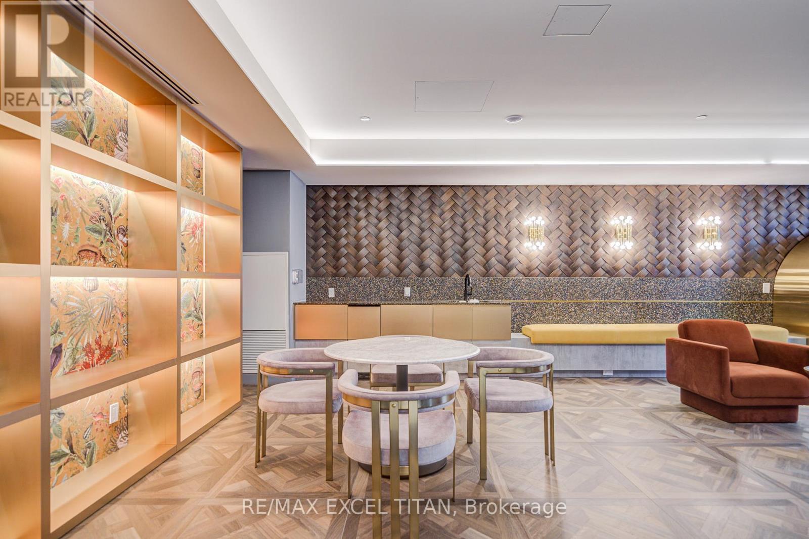 A modern office space with a dining area and a wall of pictures.