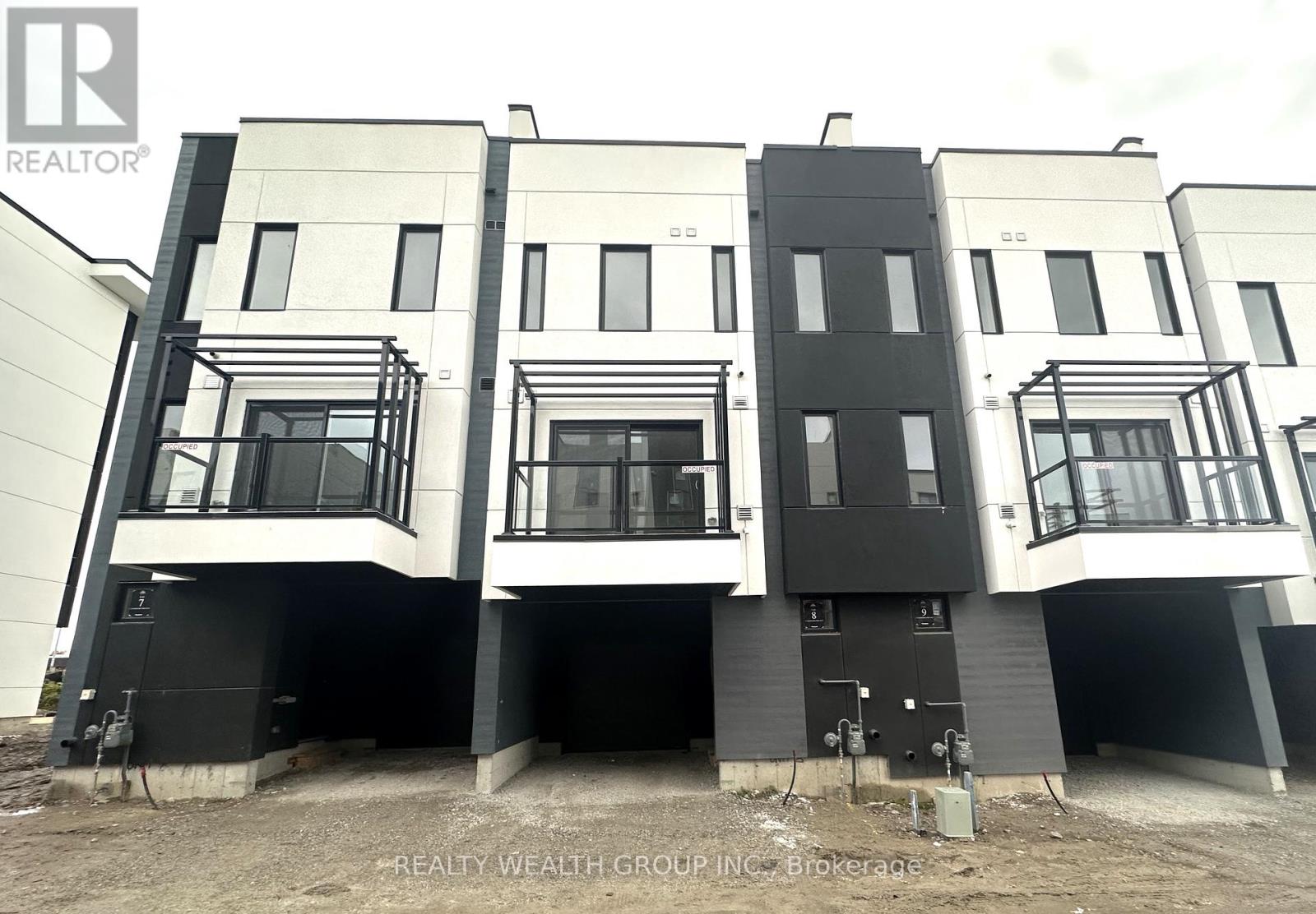 A building under construction with the logo REALTY WEALTH GROUP INC. Brokerage.