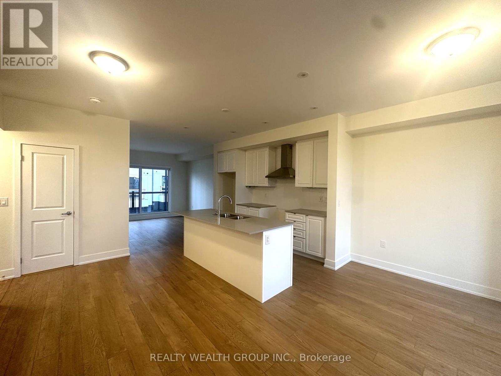 A large, empty room with wooden floors and white walls.