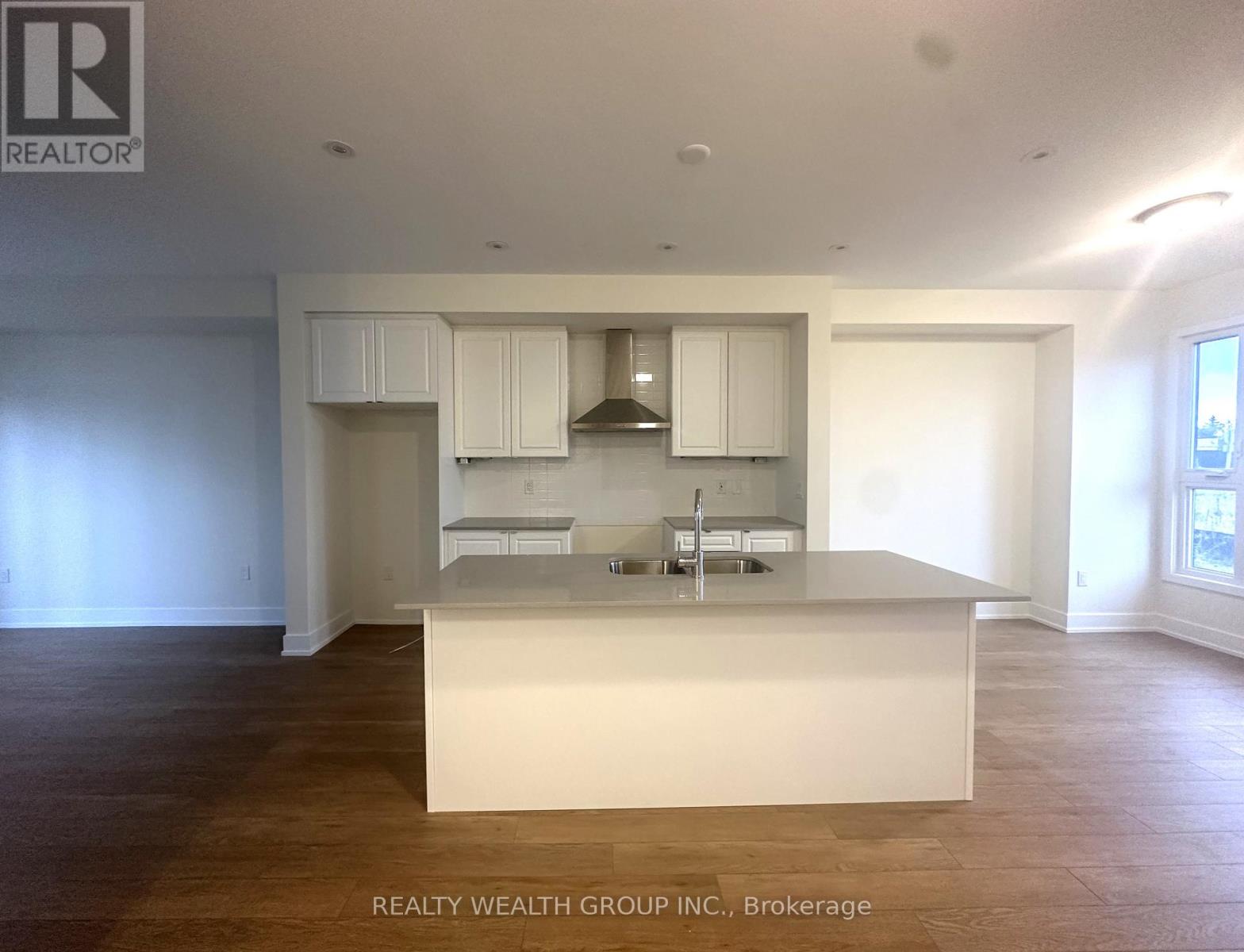 A kitchen with white cabinets and a large island.