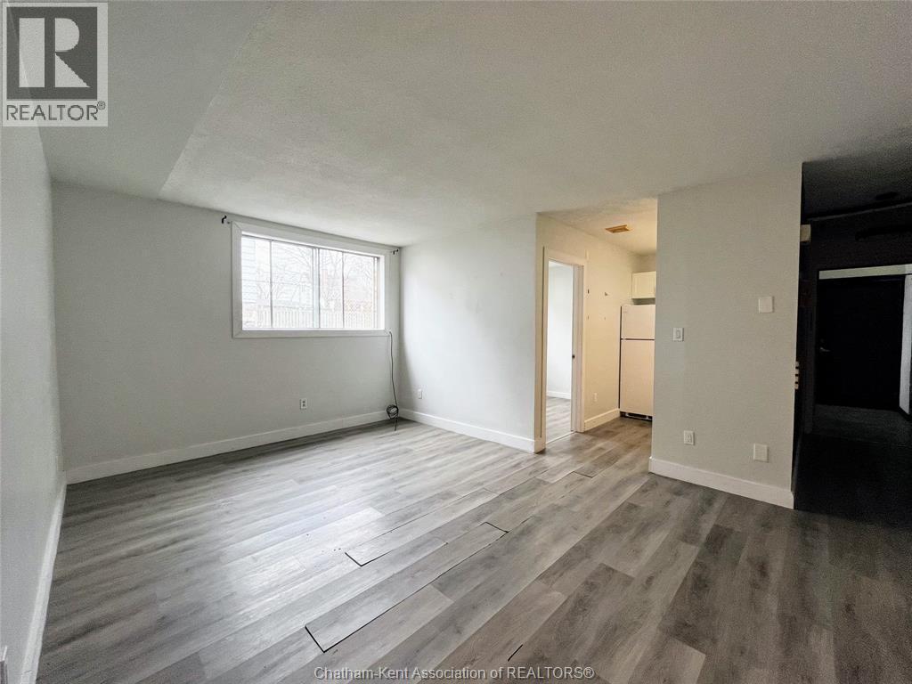 A room with wooden flooring and a window.