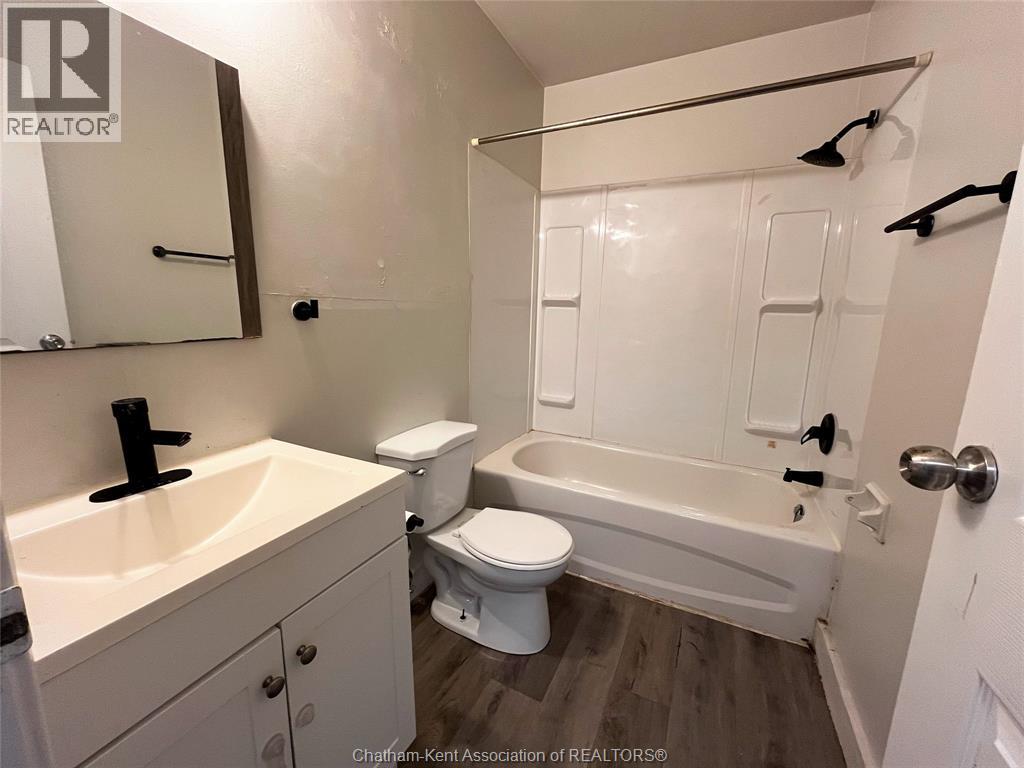 A white bathroom with a sink, toilet and bathtub.