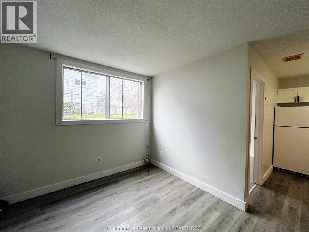 A room with a window and a door leading to another room.