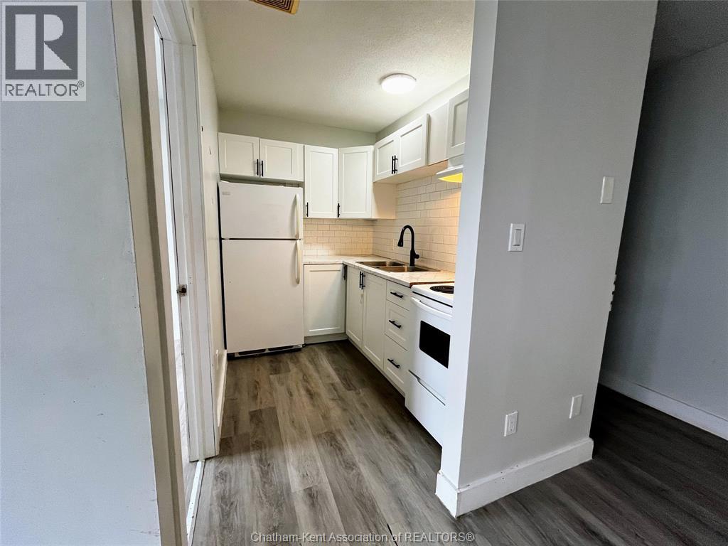 A kitchen with white appliances and cabinets.