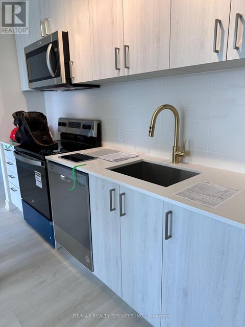 A kitchen with a sink, dishwasher, and microwave.