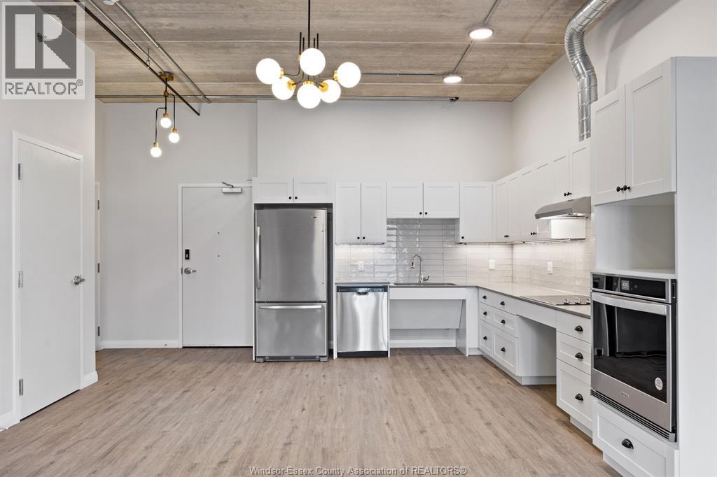 A kitchen with white cabinets and a wooden floor.