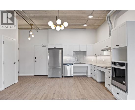 A kitchen with white cabinets and a wooden floor.