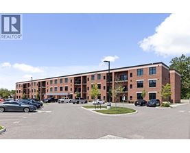 A parking lot in front of a multi-story brick building.