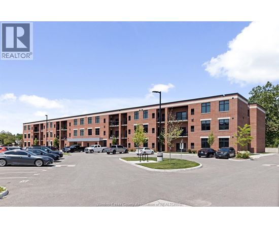 A parking lot in front of a multi-story brick building.