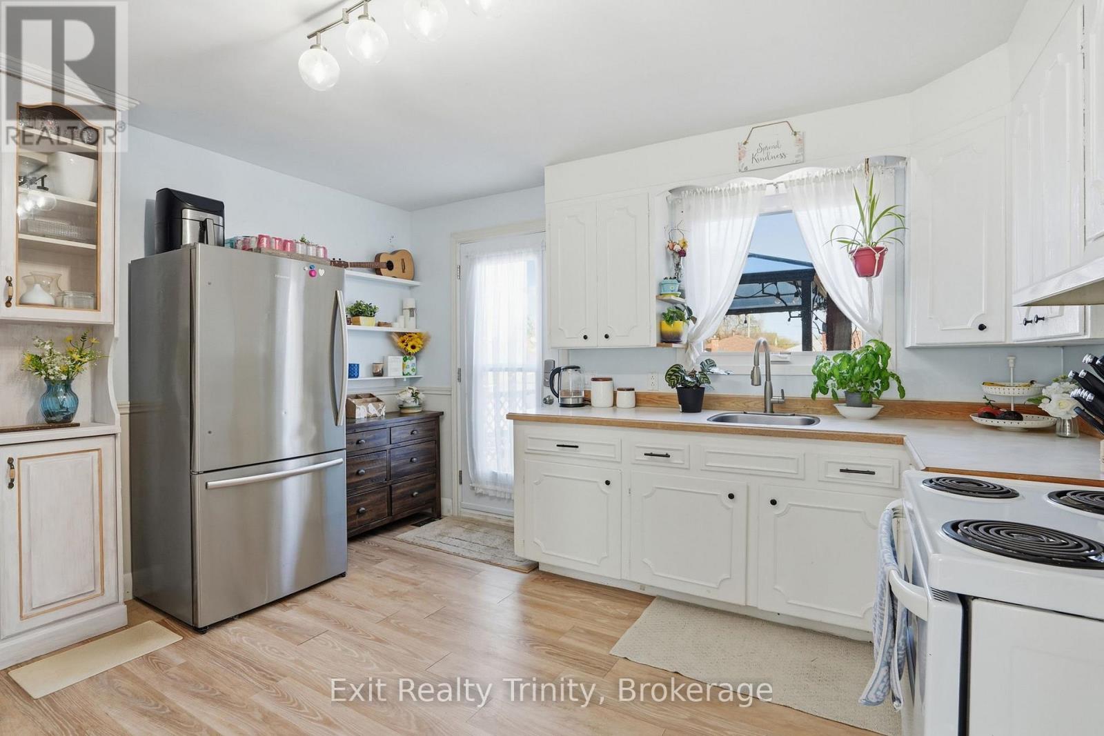 A kitchen with white cabinets and a stainless steel refrigerator.