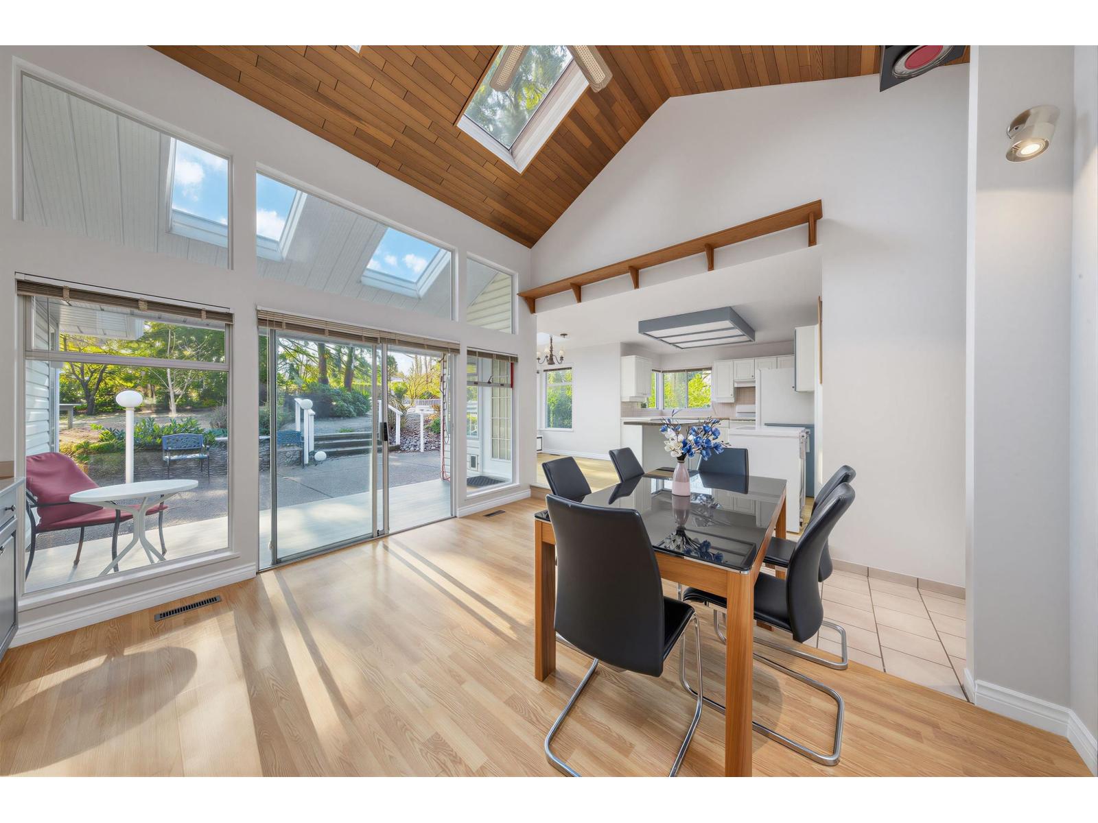 A room with a table and chairs and a skylight.