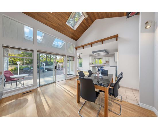 A room with a table and chairs and a skylight.