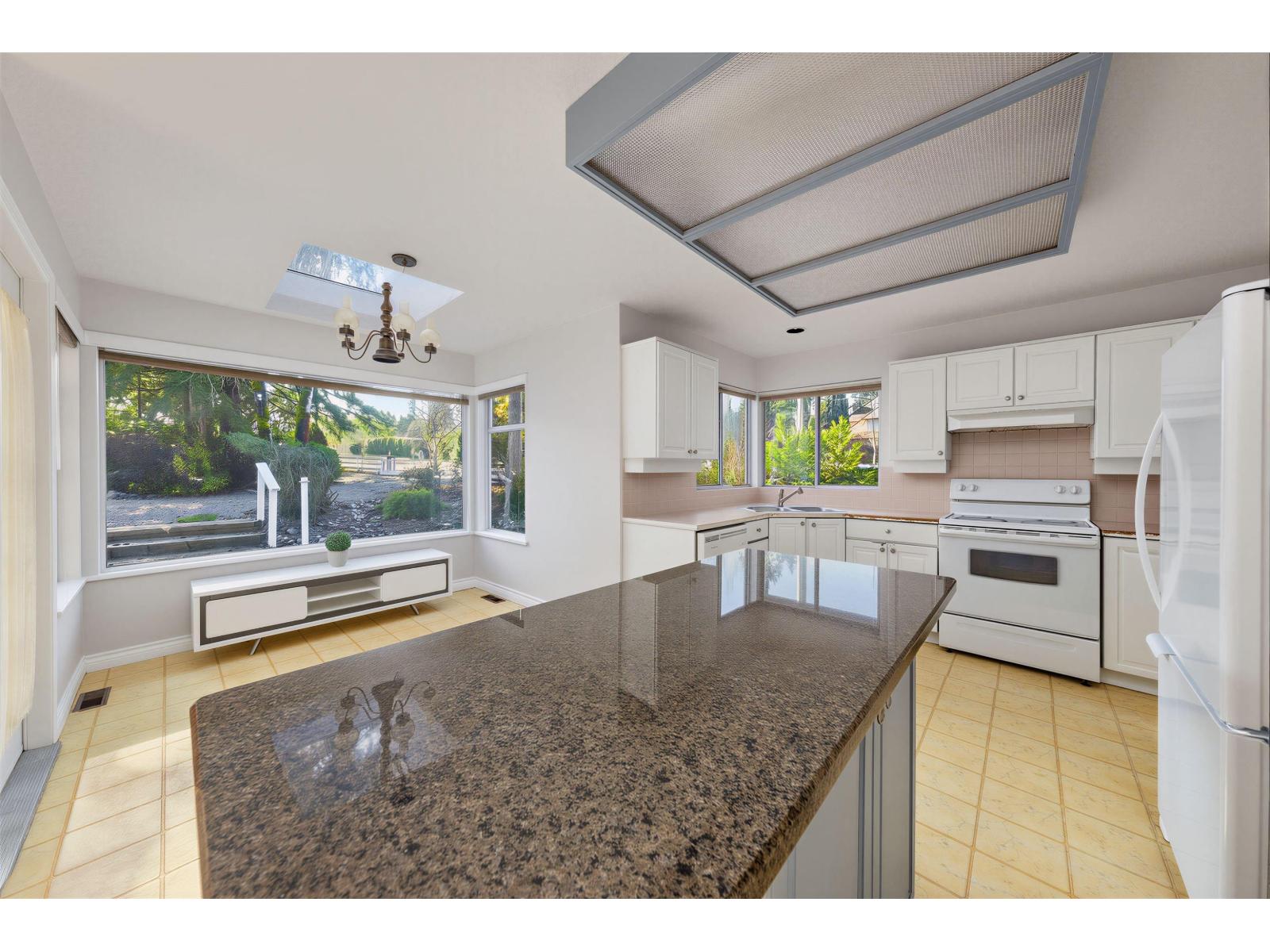A kitchen with granite countertops and stainless steel appliances.
