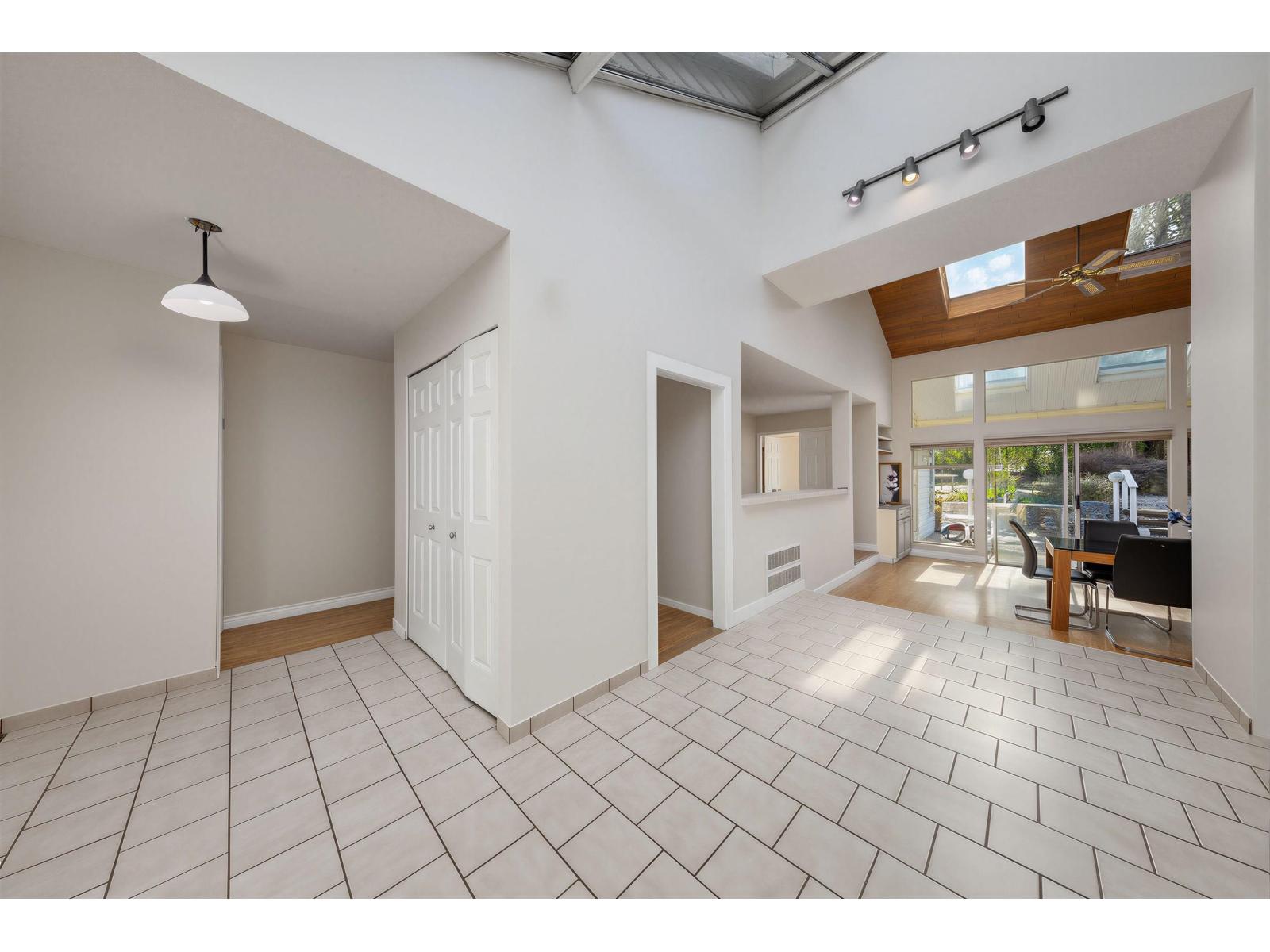 A spacious room with a tiled floor and a skylight.