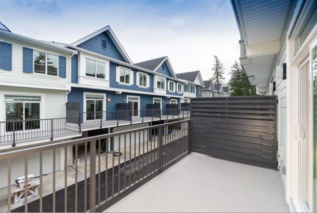 A row of houses with a fence in front.