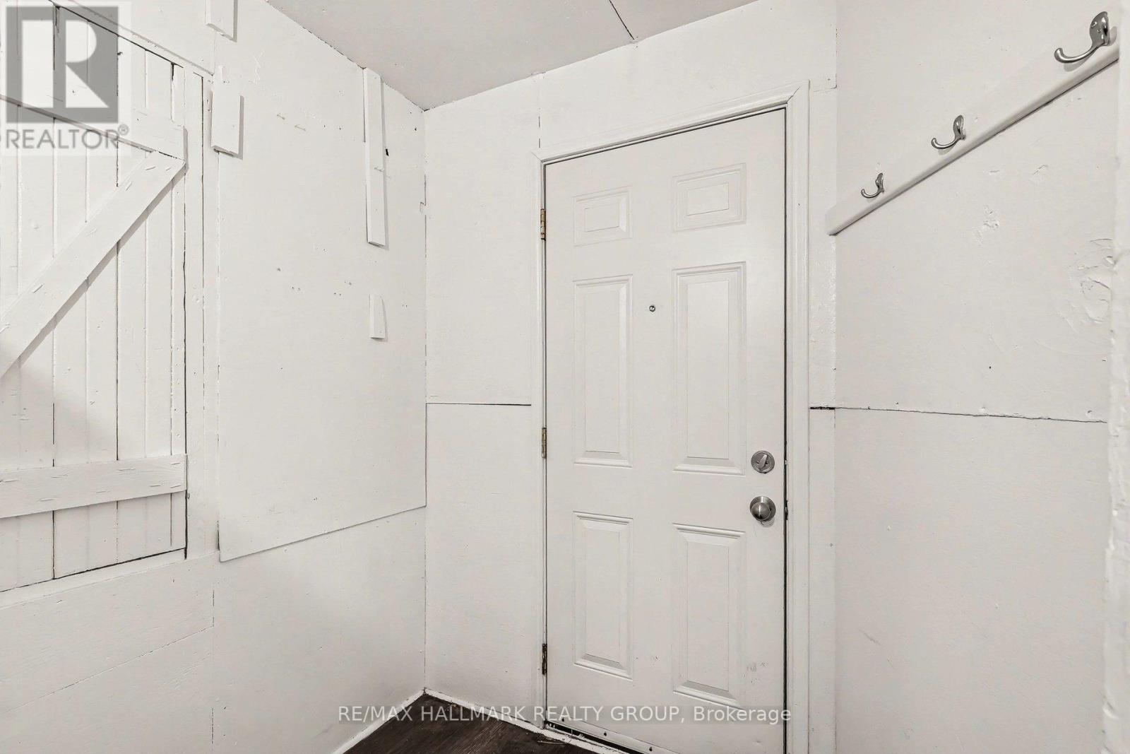A white door is in a white room.