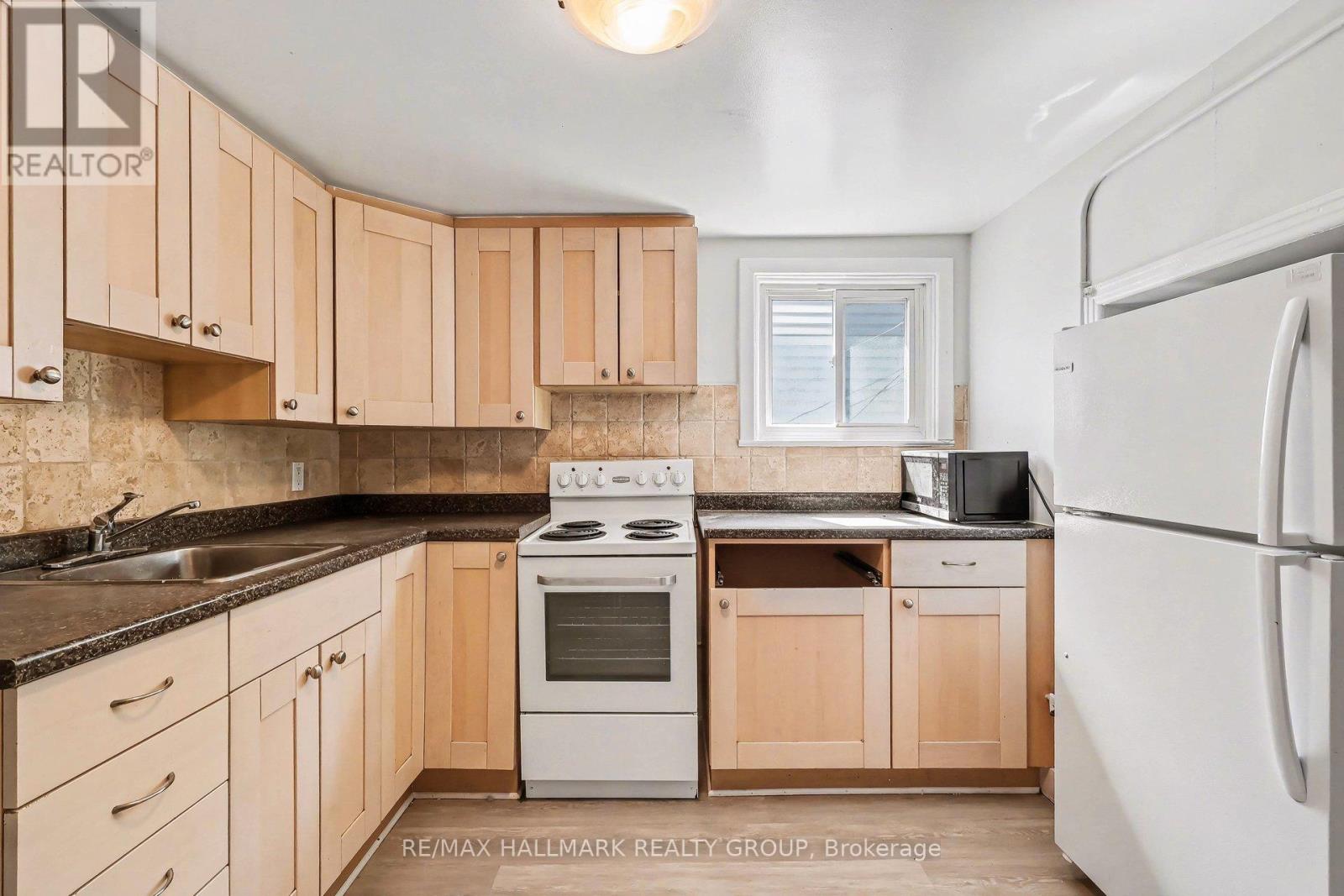 A kitchen with wooden cabinets and a white refrigerator.