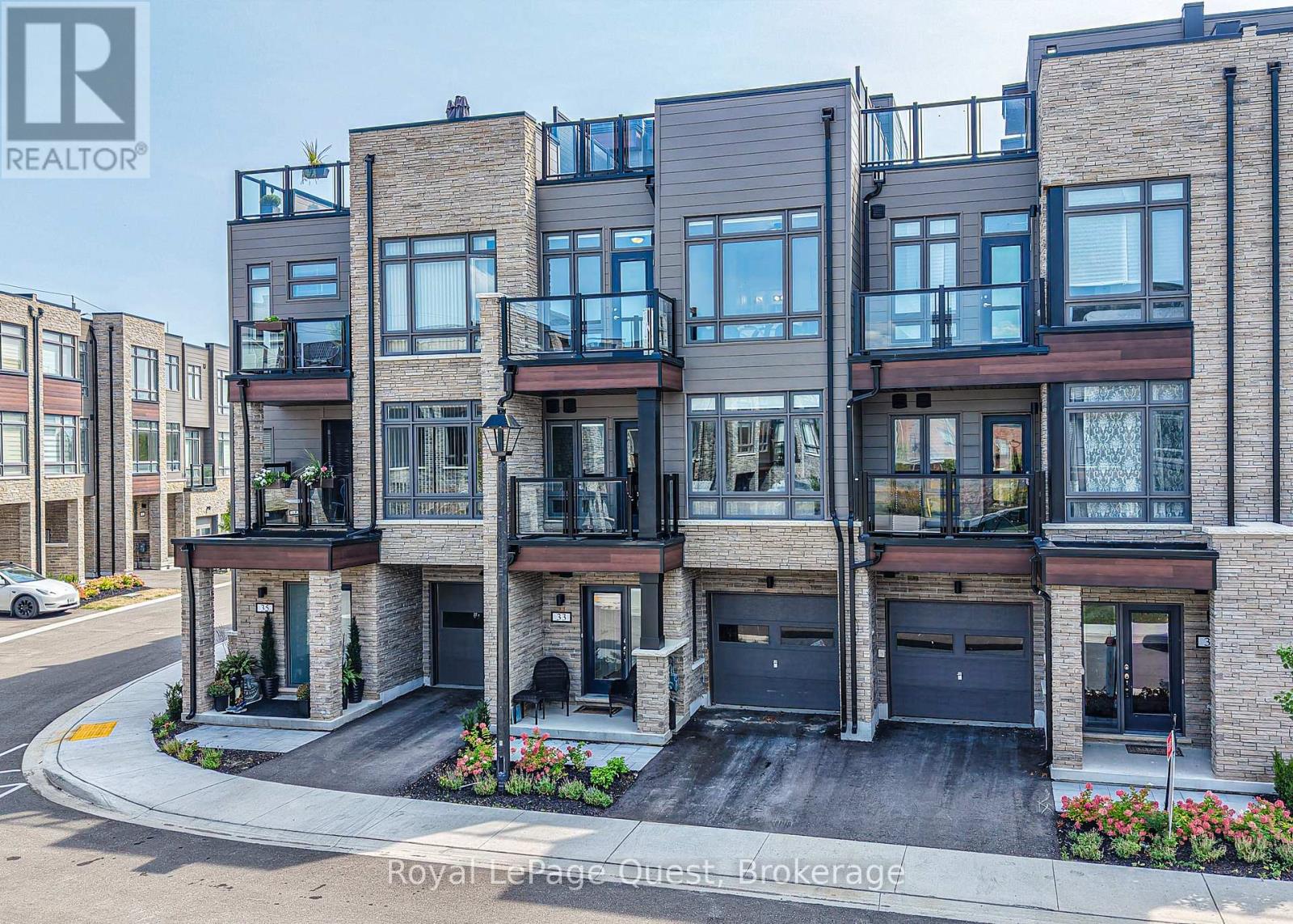 A modern multi-story building with balconies and garages is for sale.